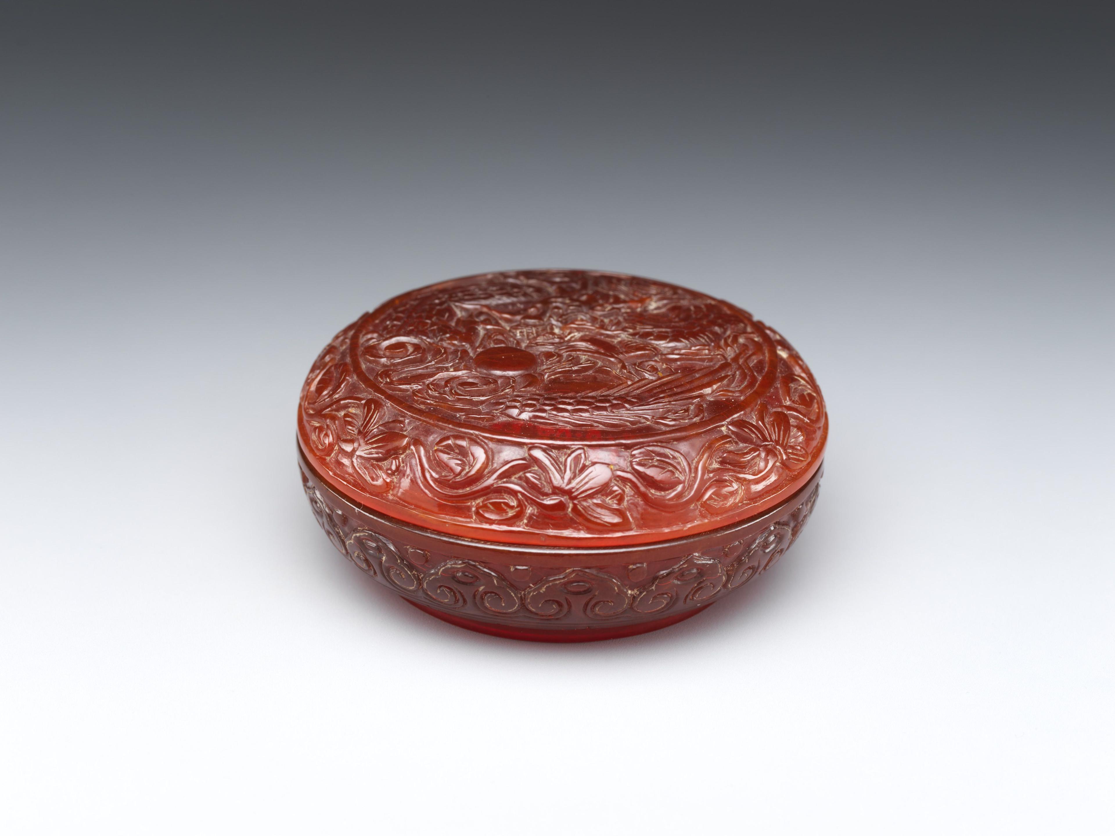 Carved reddish amber covered box with a dragon design